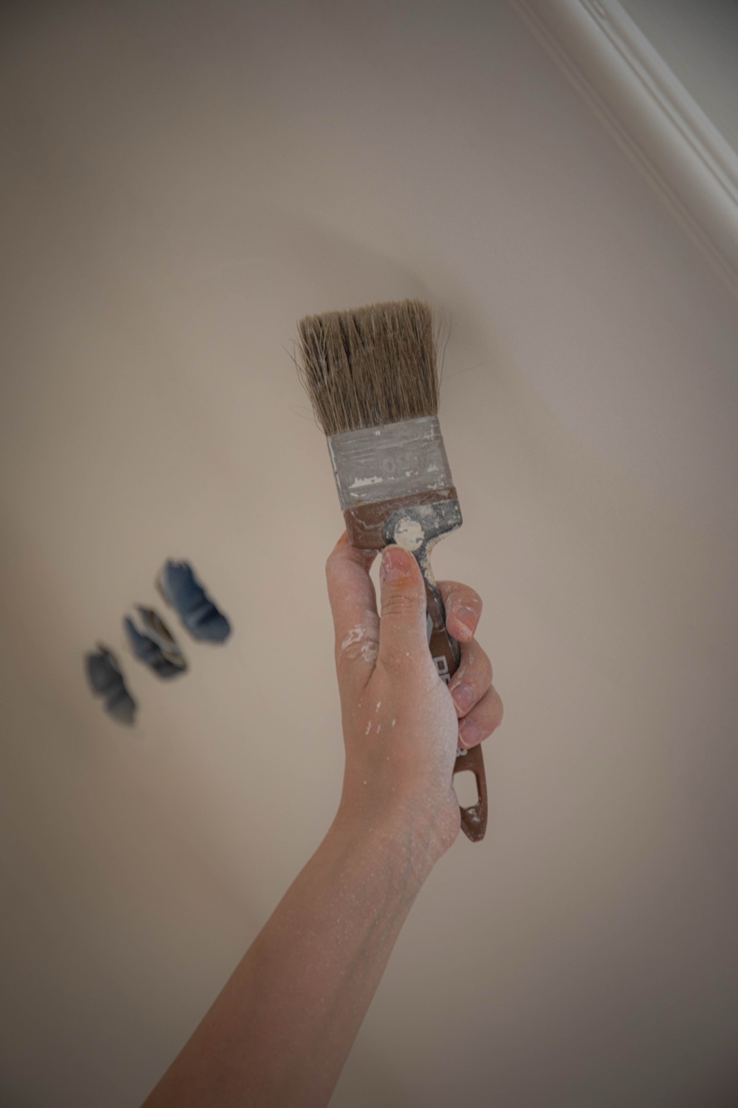 Close-up of a decorator cutting in a paint edge by hand with a brush